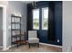 Comfortable bedroom with ladder shelf, stylish chair, and large windows with black drapes at 2215 S Delaware St, Indianapolis, IN 46225