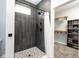 Elegant walk-in shower featuring dark tile and mosaic flooring, adjoins a closet with shelving at 2215 S Delaware St, Indianapolis, IN 46225