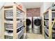 Well-organized laundry room with modern washer/dryer units and shelving for ample storage at 2258 Bridlewood Dr, Franklin, IN 46131