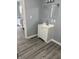 A bathroom showcases a white vanity cabinet with gray walls and updated flooring at 23 S Holmes Ave, Indianapolis, IN 46222