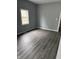 Bedroom featuring modern gray vinyl plank flooring and a large bright window at 23 S Holmes Ave, Indianapolis, IN 46222