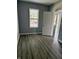 Bedroom featuring modern gray vinyl plank flooring and a view to the outdoors at 23 S Holmes Ave, Indianapolis, IN 46222