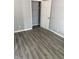 Bedroom featuring modern gray vinyl plank flooring and large closet space at 23 S Holmes Ave, Indianapolis, IN 46222