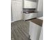 Bright kitchen with white cabinets, granite countertops, and gray vinyl plank flooring at 23 S Holmes Ave, Indianapolis, IN 46222