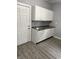 Bright kitchen with white cabinets, granite countertops, and gray vinyl plank flooring at 23 S Holmes Ave, Indianapolis, IN 46222