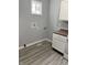 This laundry area offers a modern design with gray walls and a window for natural light, plus updated flooring at 23 S Holmes Ave, Indianapolis, IN 46222