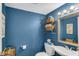 Full bathroom with blue walls, framed mirror, toilet, and shelves with baskets for storage at 237 Broadmoor Bnd, Pittsboro, IN 46167