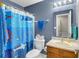Brightly decorated bathroom featuring a shower with a playful blue curtain, a vanity, and a mirror at 237 Broadmoor Bnd, Pittsboro, IN 46167