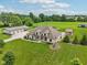 Expansive aerial view showcases a stunning home with manicured lawns, detached garages, and a serene landscape at 2825 S State Road 267, Plainfield, IN 46168