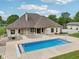 A sprawling backyard with a sparkling blue swimming pool, a concrete patio, and a well-maintained yard and home at 2825 S State Road 267, Plainfield, IN 46168