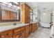 Bathroom with dual vanities, soaking tub, and wood-framed mirrors at 2825 S State Road 267, Plainfield, IN 46168