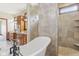 Bright bathroom featuring a soaking tub, tiled shower and a chandelier at 2825 S State Road 267, Plainfield, IN 46168