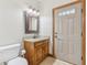 Bathroom featuring a granite vanity, toilet, accent mirror and exterior access at 2825 S State Road 267, Plainfield, IN 46168