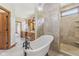 Bright bathroom featuring a soaking tub, tiled shower and a chandelier at 2825 S State Road 267, Plainfield, IN 46168
