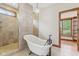 Bright bathroom featuring a soaking tub, tiled shower and a chandelier at 2825 S State Road 267, Plainfield, IN 46168
