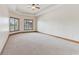Spacious carpeted bedroom featuring tray ceiling, ceiling fan and window views at 2825 S State Road 267, Plainfield, IN 46168