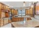 Well-lit kitchen features granite counters, stainless appliances, and custom wood cabinetry at 2825 S State Road 267, Plainfield, IN 46168