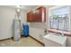 Utility room with water heater, cabinets, sink, and small window at 2825 S State Road 267, Plainfield, IN 46168