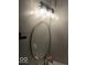 Bathroom with a round gold mirror and modern three light vanity fixture at 2968 N Arsenal Ave, Indianapolis, IN 46218