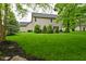 Beautifully landscaped backyard with lush green lawn, mature trees, and a patio area at 3251 Amber Way, Bargersville, IN 46106