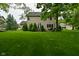 Backyard view of a home featuring lush green grass, mature trees, and a patio at 3251 Amber Way, Bargersville, IN 46106