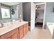 Bright bathroom featuring a double sink vanity, neutral tones, and an open doorway to the primary bedroom at 3251 Amber Way, Bargersville, IN 46106