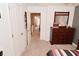 Bedroom with tan carpet, a dark wood dresser, and an open doorway to the hallway at 3251 Amber Way, Bargersville, IN 46106