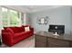 Bright home office with a large window, red sofa, modern desk, and stylish decor, perfect for productivity at 3251 Amber Way, Bargersville, IN 46106