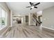 Open-concept living space with hardwood floors, ceiling fan, and staircase at 3251 Amber Way, Bargersville, IN 46106