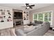 Inviting living area featuring a fireplace with stone surround, built-in shelving, and a cozy gray sectional sofa at 3251 Amber Way, Bargersville, IN 46106