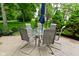 Patio with outdoor dining set and umbrella surrounded by lush greenery at 3251 Amber Way, Bargersville, IN 46106