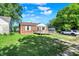 Well-maintained brick home featuring a backyard with lawn, a wooden deck, and mature shade trees at 3310 Ransdell St, Indianapolis, IN 46227
