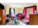 Bright bedroom showcasing a cheerful playroom rug, a fan, wood floors, and plenty of sunlight at 3310 Ransdell St, Indianapolis, IN 46227
