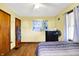 Cozy bedroom featuring wood floors, a comfortable bed, and dresser with fan at 3310 Ransdell St, Indianapolis, IN 46227