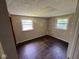 Empty bedroom showing hardwood floors and good natural light from two windows at 3403 Coffey St, Indianapolis, IN 46217