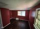 Red bedroom with hardwood floors and natural light from two windows at 3403 Coffey St, Indianapolis, IN 46217