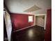 Red bedroom with hardwood floors, a window for natural light, and a closet at 3403 Coffey St, Indianapolis, IN 46217