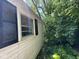 Close up of the home's exterior featuring black shutters and lush vegetation at 3403 Coffey St, Indianapolis, IN 46217