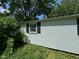 Side exterior view of a home with white siding and black shutters surrounded by greenery at 3403 Coffey St, Indianapolis, IN 46217