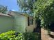 Side view of the home with white siding and black shutters nestled among lush greenery at 3403 Coffey St, Indianapolis, IN 46217