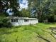 Quaint single-story home with white siding and black shutters surrounded by mature trees at 3403 Coffey St, Indianapolis, IN 46217