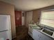 View of kitchen featuring white cabinets and appliances, and vinyl flooring at 3403 Coffey St, Indianapolis, IN 46217