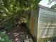 Exterior of shed with board up door surrounded by overgrown yard and foliage at 3403 Coffey St, Indianapolis, IN 46217