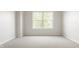Empty bedroom featuring neutral carpet, base molding, and a sunlit window at 3419 Burlingame Blvd, Carmel, IN 46074