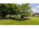 Community green space with mature trees, walking path, bench, and neighborhood homes at 3419 Burlingame Blvd, Carmel, IN 46074