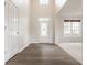 Inviting foyer featuring wood-look flooring, a stylish front door, and soaring ceilings at 3419 Burlingame Blvd, Carmel, IN 46074