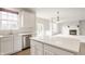 Open kitchen with white cabinets, stainless steel appliances, and island leading to living area at 3419 Burlingame Blvd, Carmel, IN 46074
