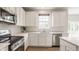 Modern kitchen featuring white cabinets, stainless steel appliances, and a window above the sink at 3419 Burlingame Blvd, Carmel, IN 46074