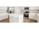 Modern kitchen island with white countertop, stainless steel appliances, and updated fixtures at 3419 Burlingame Blvd, Carmel, IN 46074