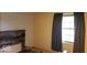 Bedroom with wallpaper, wood-look headboard, and curtains framing a window at 3702 Candy Cane Dr, Indianapolis, IN 46227